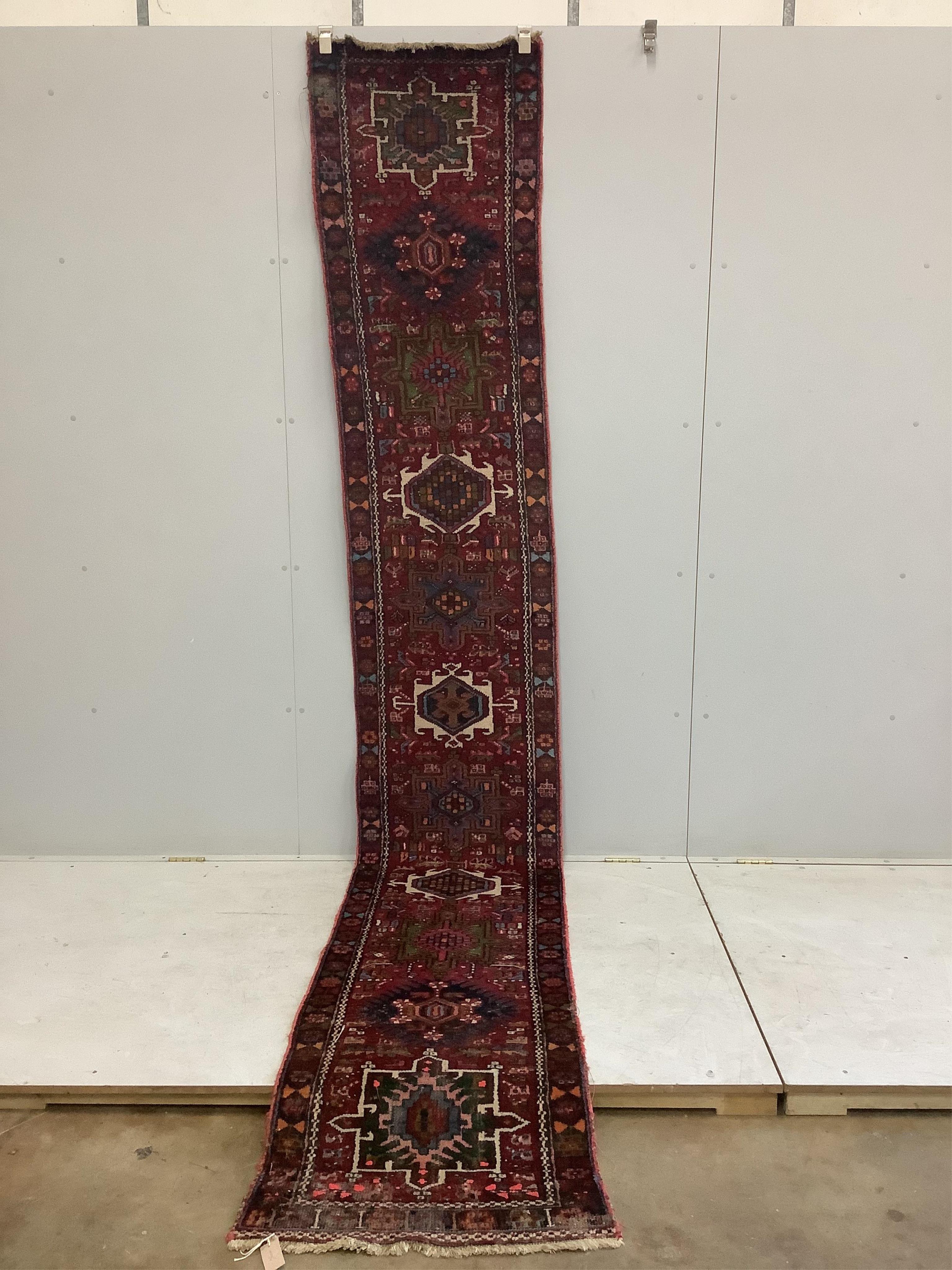 A Persian dark red ground runner, 386 x 88cm. Condition - poor, worn at both ends